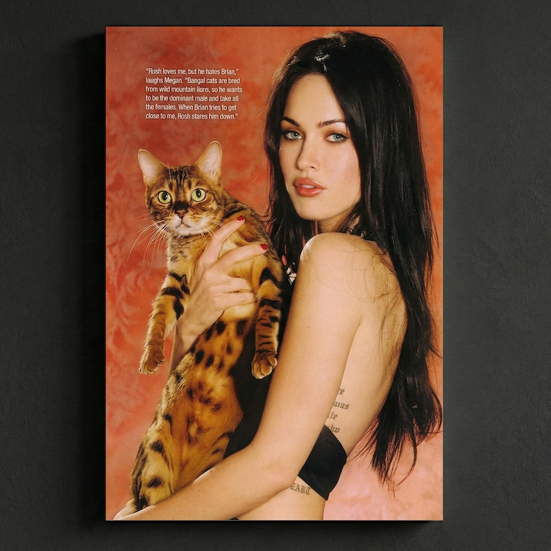 May include: A magazine cover featuring a woman holding a Bengal cat. The cat has a spotted coat with black stripes. The woman has long dark hair and is wearing a black top. Text is visible in the upper left corner.