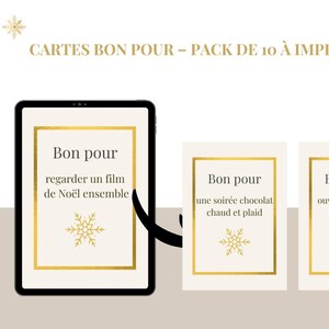 Può includere: Un tablet digitale e due biglietti con cornici dorate e disegni di fiocchi di neve. Il tablet mostra un biglietto che dice "Bon pour regarder un film de Noël ensemble." I biglietti dicono "Bon pour une soirée chocolat chaud et plaid" e "Bon pour ouvrir un cadeau en avance."