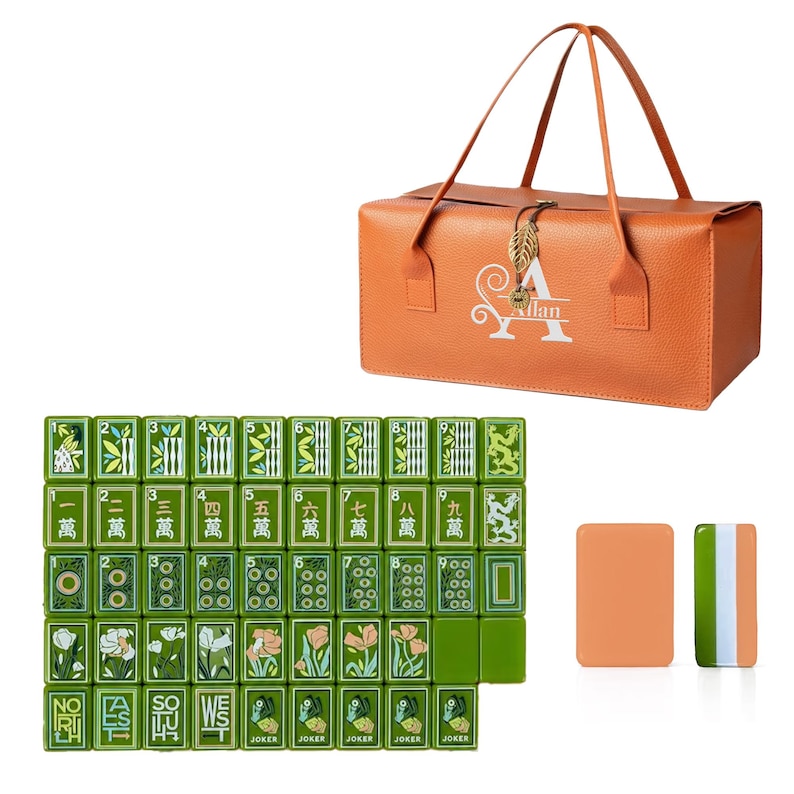 May include: An orange textured storage bag with a leaf-shaped charm and the name Allan printed on the front, accompanied by a set of green mahjong tiles featuring floral, numerical, and dragon designs, plus two additional solid-colored tiles.