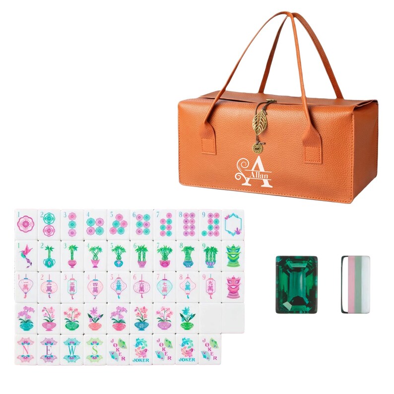 May include: An orange textured carrying case with two handles and a gold leaf charm, featuring the name Allan printed in white. Beside it are white mahjong tiles with colorful floral and character designs, plus a green rectangular tile.
