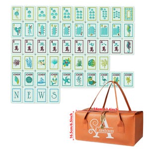 Puede incluir: Un juego de fichas de Mahjong blancas con ilustraciones azules y verdes de n&uacute;meros, caracteres chinos, vida marina y plantas, junto a un bolso de transporte naranja con una letra A blanca y la palabra Custom impresa en el frente.