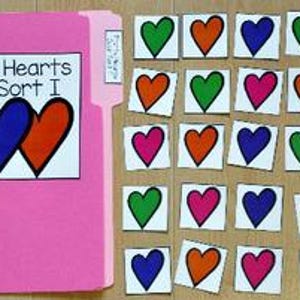 May include: A pink folder labelled "Pretty Hearts Color Sort I" with a heart illustration. Scattered around are 24 small cards, each with a coloured heart: green, orange, pink, and blue.
