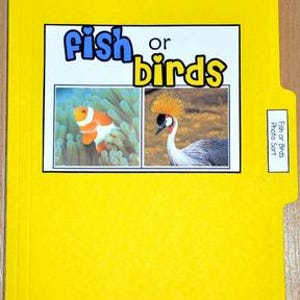 May include: A yellow file folder with the words "Fish or Birds" in blue and yellow. The folder has a photo of a clownfish and a bird. A small label on the right side reads "Fish or Birds Photo Sort."
