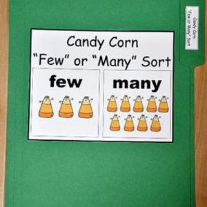 May include: A green file folder with a white paper insert. The insert reads "Candy Corn 'Few' or 'Many' Sort" with illustrations of candy corn. The words "few" and "many" are also displayed.