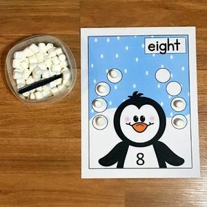Op de afbeelding: Een set van drie keramische mokken met een gespikkelde, matte afwerking. De mokken zijn in crème, lichtgrijs en donkergrijs. Elke mok heeft een eenvoudig, minimalistisch ontwerp.