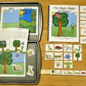 Può includere: Una collezione di materiali didattici per bambini, tra cui un libro intitolato "The Wiggly Wiggly Inchworm", flashcard e varie illustrazioni ritagliate di insetti, alberi e altri elementi naturali. Gli articoli sono disposti su una superficie di legno e all'interno di un vassoio di metallo.