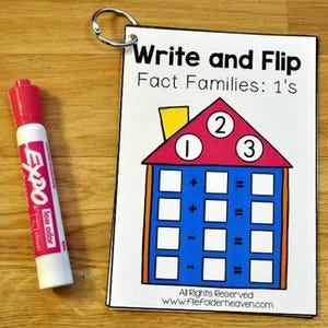 以下が含まれることがあります： 白と赤のExpo低臭気マーカーが、「Write and Flip Fact Families: 1's」という教育カードの隣にあります。カードには、数字1、2、3と数学記号が描かれたカラフルな家のグラフィックが描かれています。カードは金属リングでまとめられています。