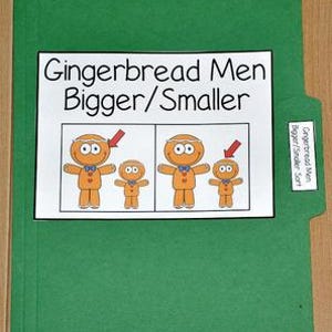 以下が含まれることがあります： 「Gingerbread Men Bigger/Smaller」の文字が入った白い紙のインサートが付いた緑色のファイルフォルダー。インサートには、さまざまなサイズのジンジャーブレッドマンのイラストが描かれており、矢印でサイズの比較を示しています。フォルダーの小さなラベルには「Gingerbread Men Bigger/Smaller Sort」と書かれています。