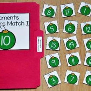May include: A red file folder with a white label reading "Ornaments Numbers Match I" and a green ornament with the number 10. Beside the folder are 19 square cards with green ornament graphics and numbers 2-20.
