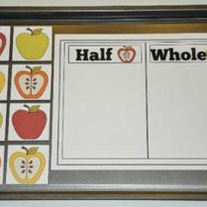 Könnte beinhalten: Ein Backblech aus Metall enthält eine Lernaktivität. Das Blech enthält ein weißes Papier mit den Wörtern "Half" und "Whole" und Apfelgrafiken. Auf der linken Seite sind sechs Apfelkarten angeordnet, jede mit einer anderen Farbe und einem anderen Design.