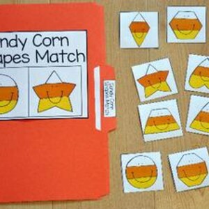 May include: An orange file folder labeled "Candy Corn Shapes Match" with matching candy corn shapes. The shapes include a circle, triangle, square, and star. The candy corn shapes are yellow, orange, and white.