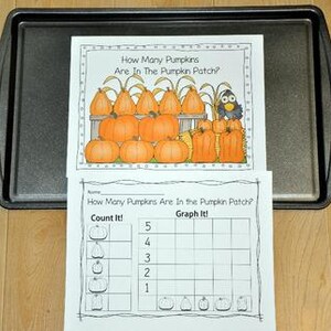 May include: Two worksheets on a baking tray. The top worksheet asks "How Many Pumpkins Are In The Pumpkin Patch?" and features illustrations of pumpkins and a bird. The bottom worksheet is a graph for counting pumpkins.