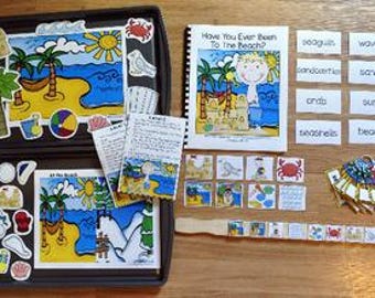 Può includere: Un set educativo per bambini a tema spiaggia, con illustrazioni e testo. Include un libro intitolato "Have You Ever Been To The Beach?" e varie schede illustrate, insieme a pezzi magnetici ed etichette.