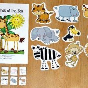 Op de afbeelding: Een kinderboek getiteld "I Saw Animals at the Zoo" met illustraties van dieren uit de dierentuin. Inclusief uitgesneden dierenfiguren en kleine plaatjes van dieren. Het boek en de figuren liggen op een houten oppervlak.