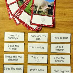 May include: A set of flashcards with farm animal photos and corresponding text. The cards are red-bordered with images of pigs, sheep, and other animals. The text cards include phrases like "I see the turkeys" and "This is a goat."