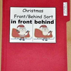 May include: A red file folder with a white label featuring the text "Christmas Front/Behind Sort" and illustrations of Santa Claus in a sleigh. The words "in front behind" are also visible.