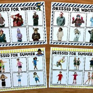 May include: Four educational cards with the text "DRESSED FOR WINTER" and "DRESSED FOR SUMMER". Each card displays images of children in different outfits. The cards have a white background with blue and yellow borders.