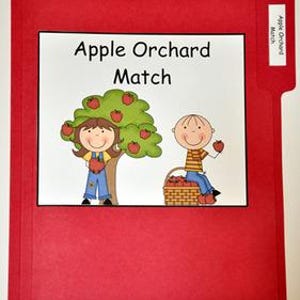 May include: A red file folder with a white rectangle containing the text "Apple Orchard Match" and an illustration of two children and an apple tree. One child holds an apple, and the other sits by a basket of apples. A small label on the folder reads "Apple Orchard Match".