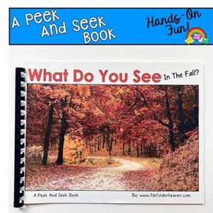 Puede incluir: Un libro encuadernado en espiral titulado "What Do You See In The Fall?" con una imagen de portada de un camino que serpentea a través de un bosque de árboles con hojas rojas y naranjas. El título del libro está en letras rojas grandes.
