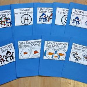 May include: A set of blue file folders, each labelled with a different educational activity featuring snowman graphics. Titles include "Snowmen Beginning Sounds," "Snowball Numbers Match," and "Silly Snowmen Color Sort."