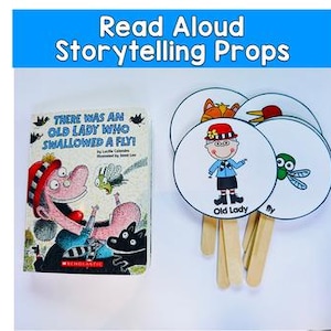 Pode incluir: Um livro infantil intitulado "THERE WAS AN OLD LADY WHO SWALLOWED A FLY!" é exibido ao lado de quatro adereços circulares de contação de histórias. Os adereços apresentam ilustrações de uma velha, uma mosca, uma raposa e um pássaro. O texto "Read Aloud Storytelling Props" está no topo.
