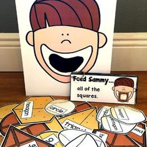 May include: A learning game featuring a cartoon face with an open mouth, labeled "Feed Sammy... all of the squares." Various geometric shapes, including triangles, hexagons, and circles, are scattered in front of the face.