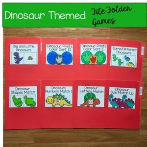 Pode incluir: Jogos de pastas vermelhas com etiquetas temáticas de dinossauros. Os rótulos incluem "Dinossauros Grandes e Pequenos", "Classificação de Cores de Impressões de Dinossauros II", "Classificação de Cores de Impressões de Dinossauros I", "Mesmos/Diferentes Dinossauros", "Combinação de Formas de Dinossauros".