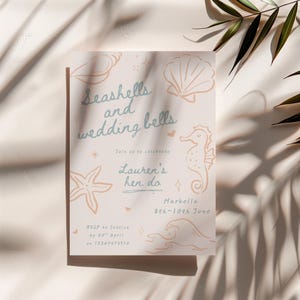 Peut inclure: Une invitation rose clair avec le texte "Seashells and wedding bells" et des illustrations de coquillages, d'un hippocampe et de vagues. L'invitation indique "Lauren's her do" et comprend les informations RSVP et la date de l'&eacute;v&eacute;nement.
