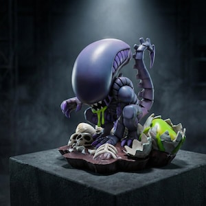 Könnte beinhalten: Eine lila-graue Xenomorph-Figur mit großem Kopf und langem Schwanz. Die Figur steht auf einem Sockel mit Schädeln, Knochen und einem zerbrochenen Ei. Grüner Schleim tropft aus dem Mund. Ein Sammlerobjekt.