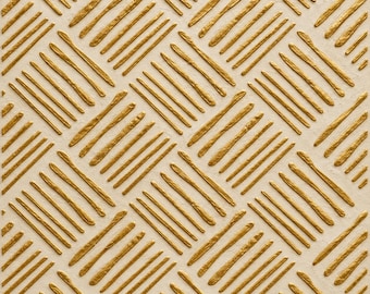 May include: A square panel featuring a textured off-white base with a raised, metallic gold geometric pattern. The design consists of repeating blocks of parallel diagonal lines oriented in alternating directions to create a grid.