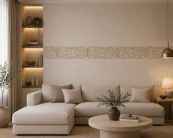 May include: A beige sectional sofa with a chaise lounge, featuring several matching throw pillows. A round, light-colored coffee table sits in front of the sofa, holding a small plant and books. A decorative carved wooden wall panel is mounted above.