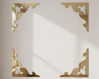 May include: Four gold-colored mirror corner accents featuring ornate, curved, and symmetrical scrollwork patterns. These reflective decorative pieces are arranged to form the corners of a square frame, each displaying a polished metallic finish.