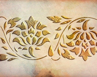 May include: A horizontal decorative panel featuring two symmetrical gold-colored floral motifs with embossed textures. The design consists of stylized petals, leaves, and curved stems set against a light, mottled, off-white and beige background.