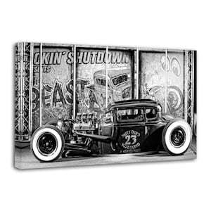 Peut inclure: Impression sur toile en noir et blanc d'un hot rod vintage avec des pneus à flancs blancs. La voiture porte le numéro 23 et l'inscription "Skoty Chops Kustoms". L'arrière-plan présente un style graffiti et les mots "Lockin' Shutdown".