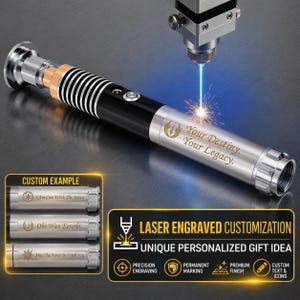 Puede incluir: Una empu&ntilde;adura de sable de luz de metal plateado y negro con una m&aacute;quina de grabado l&aacute;ser marcando el texto Your Destiny. Your Legacy. en el lateral. La empu&ntilde;adura tiene un agarre estriado, un bot&oacute;n de encendido circular y acabado met&aacute;lico.