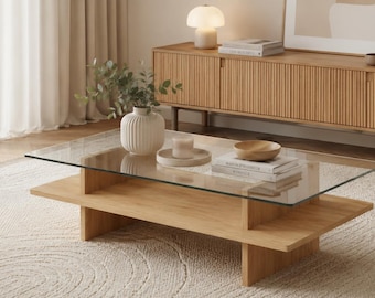 Tavolino da caffè moderno con base in legno e piano in vetro, ideale per soggiorni minimalisti.