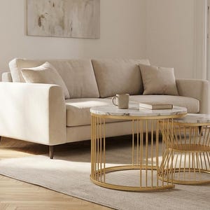 Puede incluir: Una taza de cerámica blanca con asa negra y el texto "But First, Coffee" en negrita negra. La taza se encuentra sobre un fondo borroso, sugiriendo un ambiente acogedor.