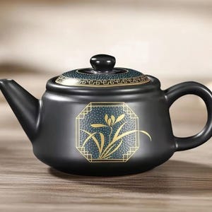 May include: Black ceramic teapot with a curved spout and handle. The lid and body feature gold and teal geometric designs. A gold floral design is centered on the teapot's body. The teapot is designed for brewing tea.