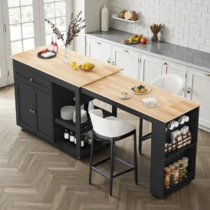 May include: A black kitchen island with a light wood countertop and a built-in table extension. The island features storage cabinets, shelves, and a wine rack. Two white bar stools are positioned at the table.