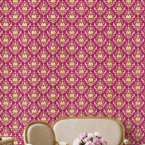 Könnte beinhalten: Ein Raum mit klassischem Design mit magenta- und goldfarbenem Damasttapeten. Der Raum umfasst ein Sofa, Stühle, einen Couchtisch und einen Spiegel. Ein Kamin und ein Tisch mit einer Lampe sind ebenfalls sichtbar.