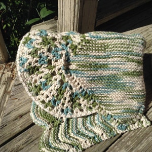 May include: A crocheted throw blanket with a white, green, and blue striped pattern. The blanket has a crocheted border with a circular design.
