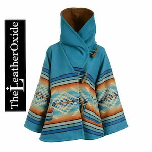 Könnte beinhalten: Ein türkisfarbener Kapuzenponcho mit braunem Innenfutter und Knebelverschlüssen aus Holz. Der Poncho hat ein vom Südwesten inspiriertes geometrisches Muster in Blau-, Orange- und Cremetönen. Der Text "The Leather Oxide" befindet sich auf der linken Seite.