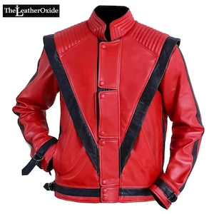 May include: A red leather jacket with black detailing. The jacket has a stand-up collar, quilted shoulder panels, and black stripes on the sleeves and front. It features a button-up front and buckle fastenings on the cuffs and waist.