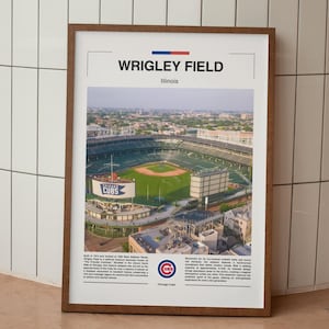 May include: A framed print of Wrigley Field, Illinois, home of the Chicago Cubs. The image shows an aerial view of the baseball stadium with a green field, seating, and surrounding buildings. The print has a brown wooden frame and includes the Chicago Cubs logo.