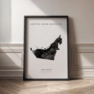 Könnte beinhalten: Ein gerahmter Druck mit einer schwarz-weißen Karte der Vereinigten Arabischen Emirate. Die Karte ist mit einem dunklen, strukturierten Design gefüllt. Die Texte "UNITED ARAB EMIRATES" und "ABU DHABI" sind oberhalb und unterhalb der Karte zu sehen.