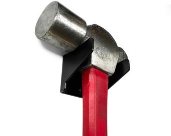 Puede incluir: Un soporte de martillo de metal negro con un martillo de mango rojo. El martillo tiene una cabeza plateada.