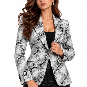 May include: A tailored blazer featuring a monochromatic snakeskin print in shades of white, gray, and black. The jacket includes a notched lapel, a single front button closure, two flap pockets, and three decorative buttons on each sleeve cuff.