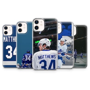 May include: A collection of five phone cases featuring hockey player Auston Matthews. The cases display images of Matthews in his Toronto Maple Leafs jersey, with the number 34 prominently displayed. The cases are in various shades of blue and white.
