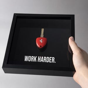 Ferrari-Schlüssel eingerahmt - WORK HARDER | Motivierende Wandkunst