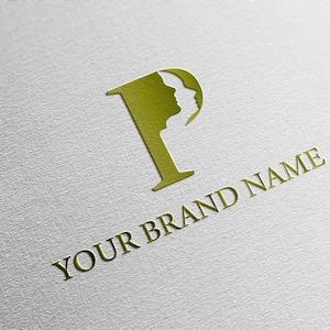 Puede incluir: Logotipo dorado con la letra "P" que incorpora la silueta de dos rostros. Debajo, las palabras "YOUR BRAND NAME" están impresas en dorado. El diseño se encuentra sobre un fondo blanco texturizado.